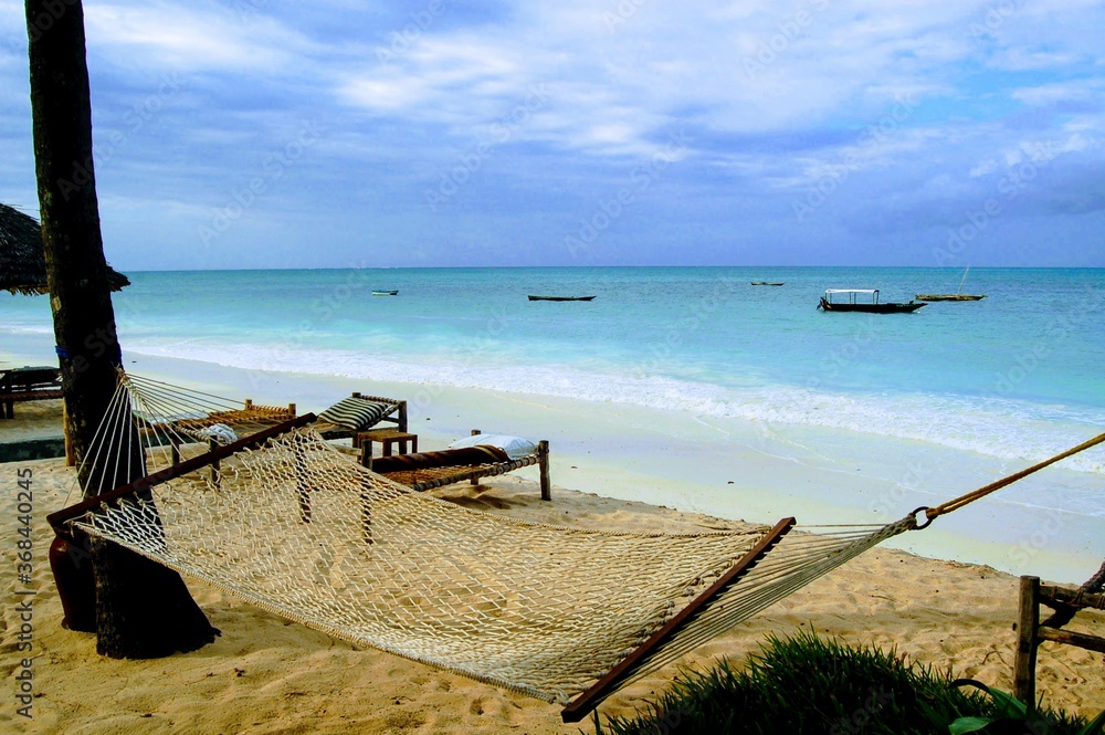 Hammock on the beach with clear blue waters in Zanzibar