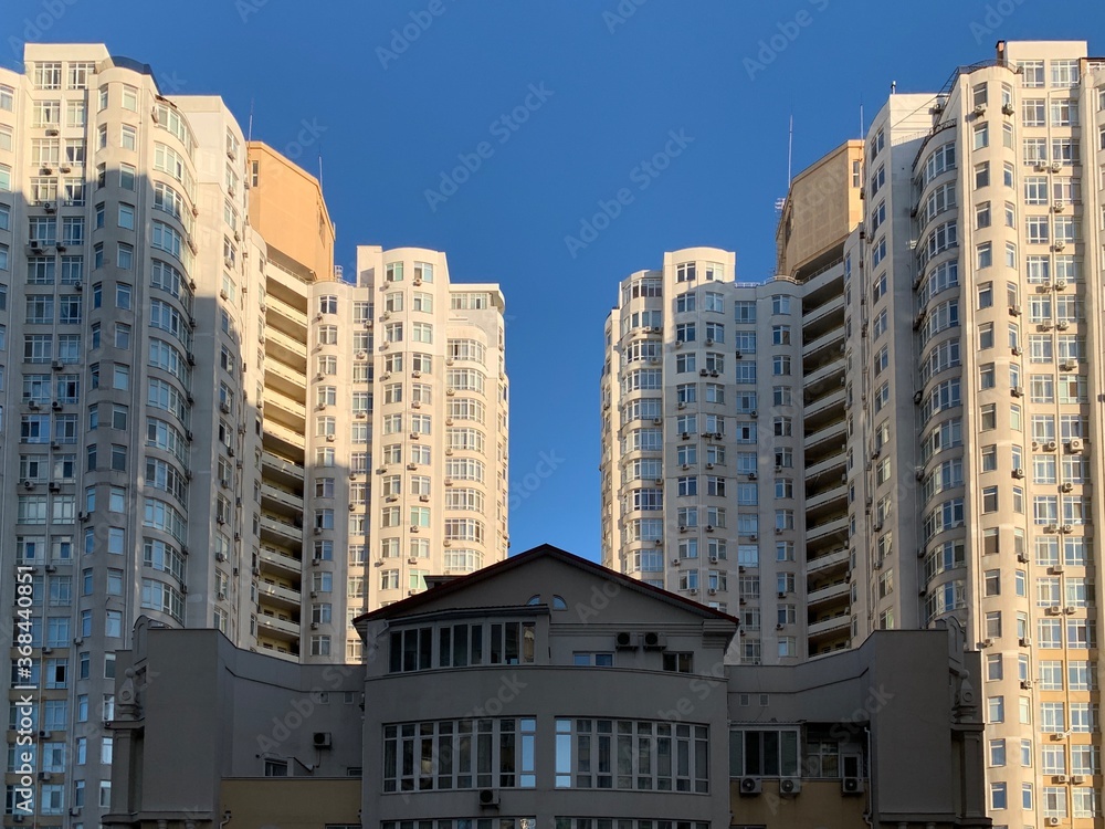 Multi-storey building against the blue sky. Tall new building with no windows, bottom view. Background texture: high-rise, skyscraper. Odessa, fransuzkiy boulevard, july 1, 2020 Multi-storey building against the blue sky. Tall new building with no windows, bottom view. Background texture: high-rise, skyscraper. Odessa, fransuzkiy boulevard, july 1, 2020