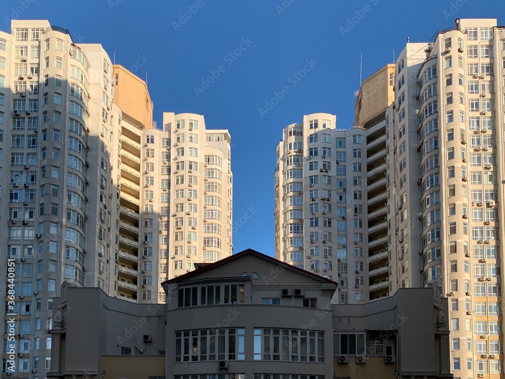 Multi-storey building against the blue sky. Tall new building with no windows, bottom view. Background texture: high-rise, skyscraper. Odessa, fransuzkiy boulevard, july 1, 2020