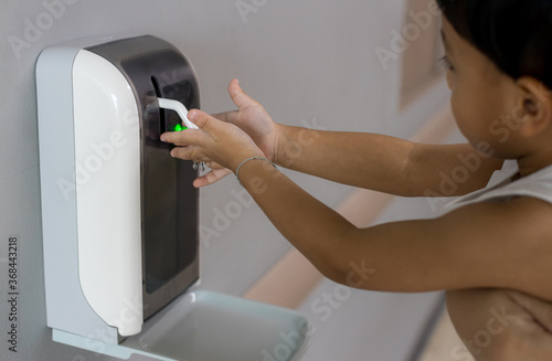 Hands under the automatic alcohol dispenser. Infection and hospitably concept. save and protect disease virus against germs and clean in the public area. Clean your hand  protect corona virus. photo