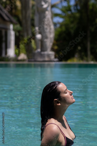Young woman relaxing in the pool water. Summer vacation concept