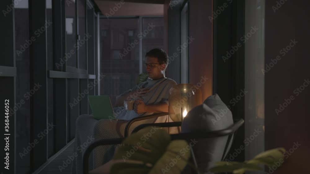 Handsome Caucasian Man Videoconferencing At Home In A Modern Apartment Using His Laptop Handsome Caucasian Man Videoconferencing At Home In A Modern Apartment Using His Laptop