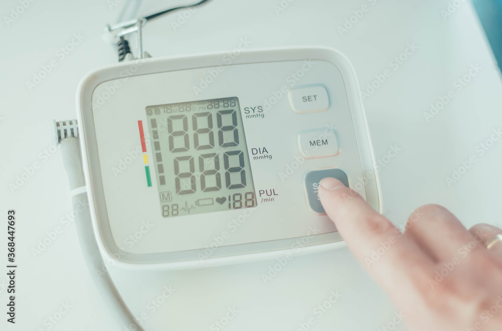 A person's finger turns on an electronic tonometer to measure blood pressure
A person's finger turns on an electronic tonometer to measure blood pressure