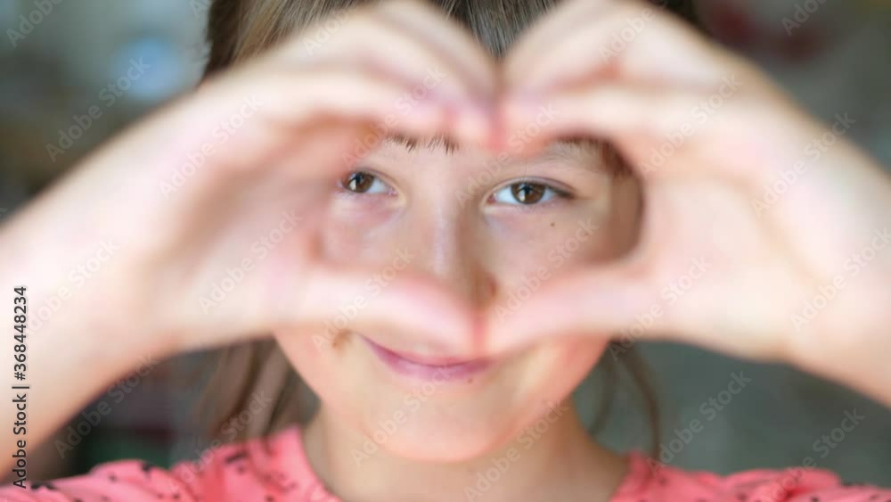 young smiling girl makes heart sign with her hands young smiling girl makes heart sign with her hands