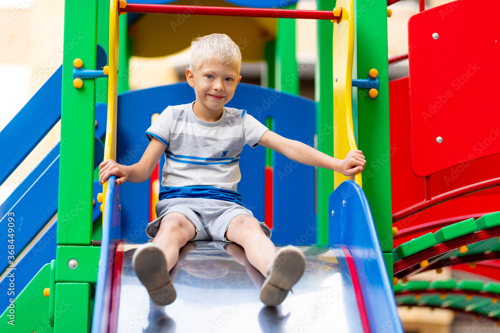 Fototapeta premium happy baby boy 5-6 years old playing on the Playground in the yard in the summer. Children's lifestyle