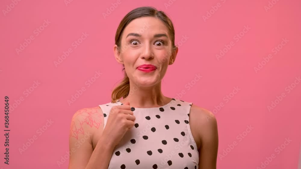 Young woman standing against the backdrop of a pink wall came up with a brilliant idea. Female in a light dress raises her finger up coming up with an idea and a plan for it is the implementation. Young woman standing against the backdrop of a pink wall came up with a brilliant idea. Female in a light dress raises her finger up coming up with an idea and a plan for it is the implementation.