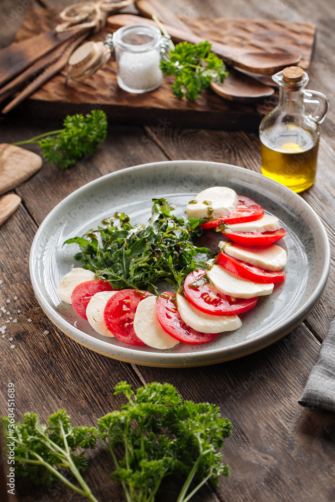 Classic italian caprese salad on the wooden table Classic italian caprese salad on the wooden table