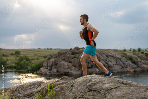 Male runner running over stones  copy of free space.