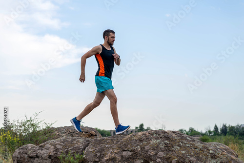 Male runner running over stones, copy of free space.