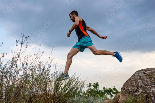 Male runner running over stones, copy of free space.