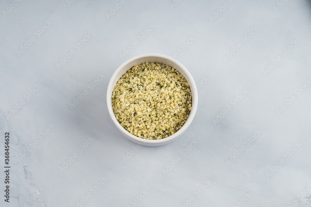 Shelled hemp seeds superfood in white bowl Shelled hemp seeds superfood in white bowl