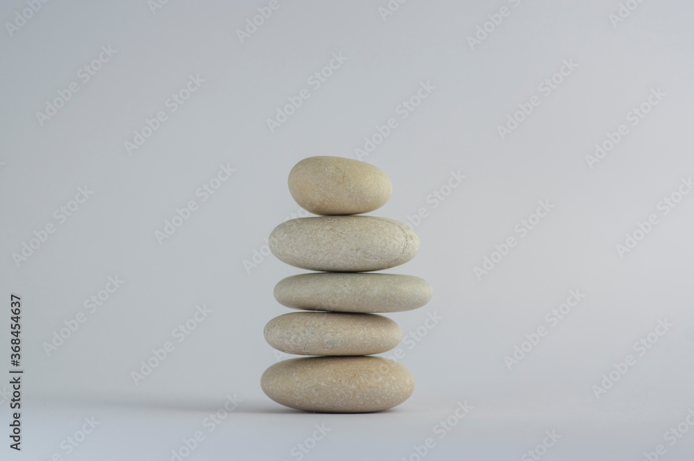 One simplicity stones cairn isolated on white background, group of five white pebbles in tower One simplicity stones cairn isolated on white background, group of five white pebbles in tower