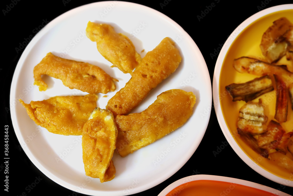 South Indian Potato Snack, Vazhakkai Bajji served on black background South Indian Potato Snack, Vazhakkai Bajji served on black background