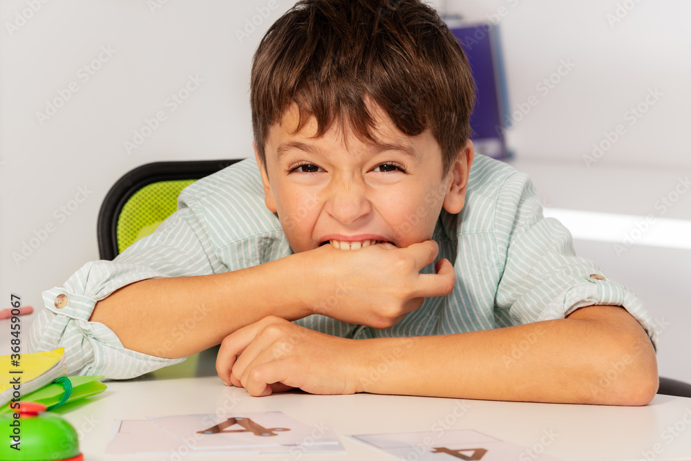 Boy with autism spectrum disorder bite hand and negative expression behavior during development therapy class lesson Boy with autism spectrum disorder bite hand and negative expression behavior during development therapy class lesson
