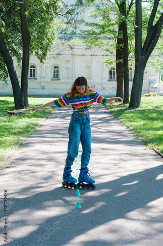 Beautiful girl having fun roller-skating in the park in the summer, vyponyaet tricks and toured chips photo