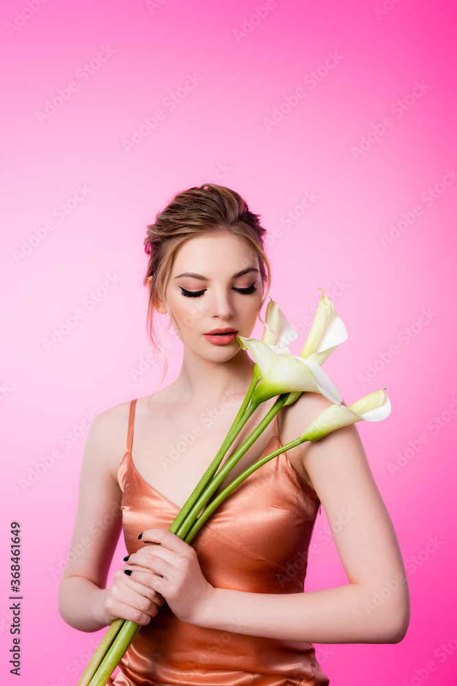 elegant beautiful blonde woman holding calla flowers isolated on pink elegant beautiful blonde woman holding calla flowers isolated on pink