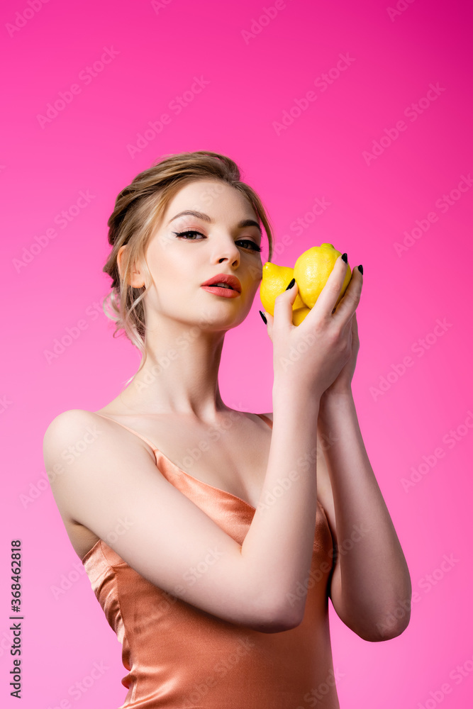 elegant beautiful blonde woman holding ripe lemons isolated on pink elegant beautiful blonde woman holding ripe lemons isolated on pink