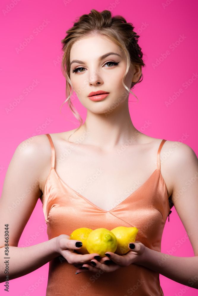elegant beautiful blonde woman holding ripe lemons isolated on pink elegant beautiful blonde woman holding ripe lemons isolated on pink