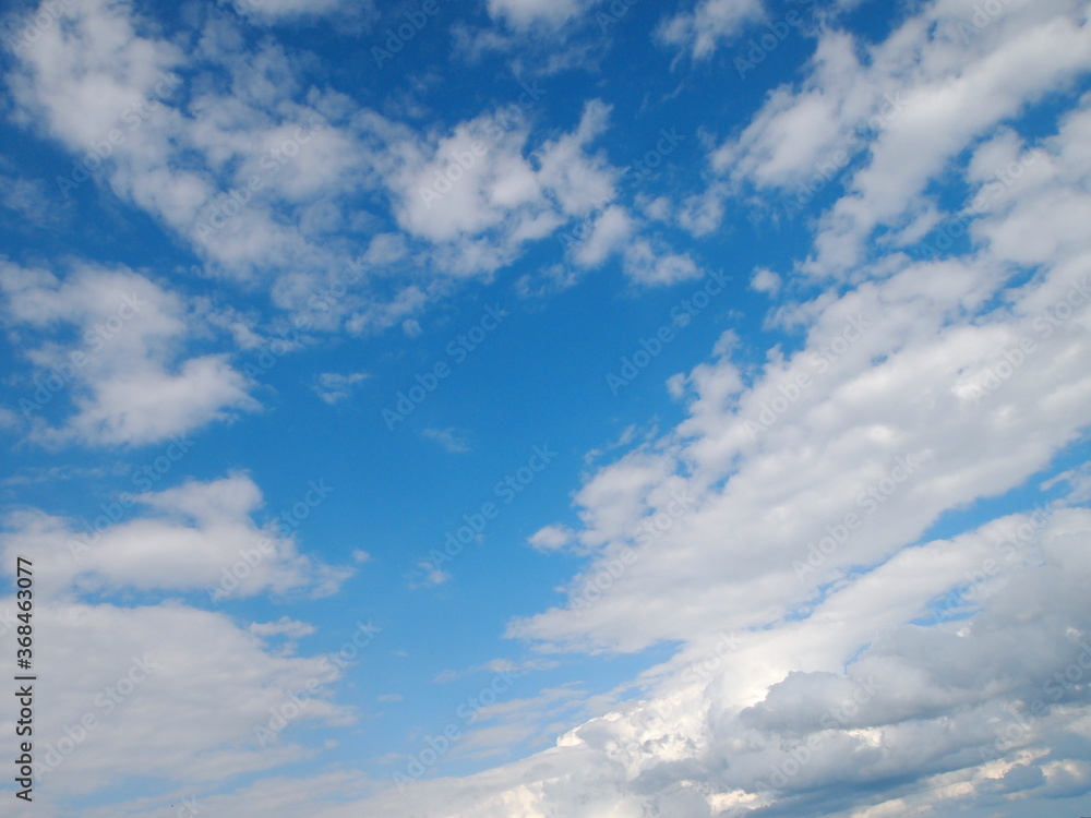 Fototapeta premium Texture blue sky with white fluffy clouds on a sunny day.