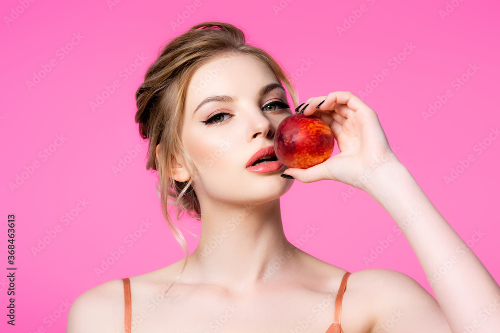elegant beautiful blonde woman holding peach isolated on pink elegant beautiful blonde woman holding peach isolated on pink