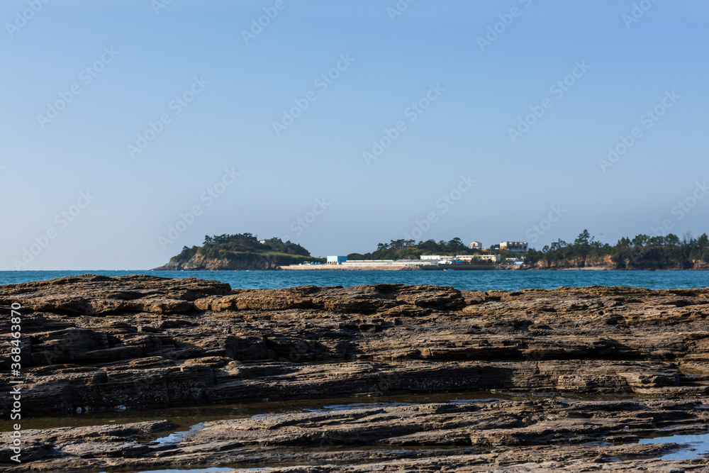 Aerial top view of sea waves hitting rocks on the beach