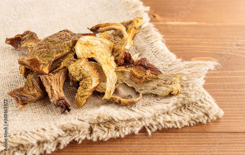 Dried mushrooms on burlap on a wooden background. Organic, eco-friendly food