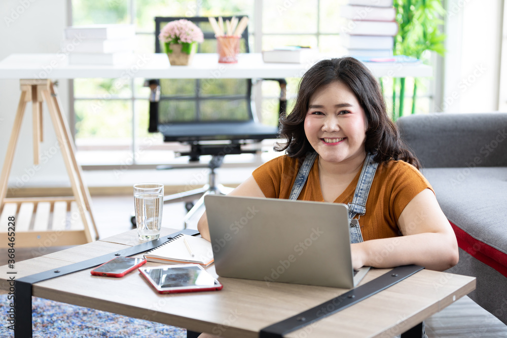 Portrait smile chubby woman works from home and studying with computer laptop Portrait smile chubby woman works from home and studying with computer laptop