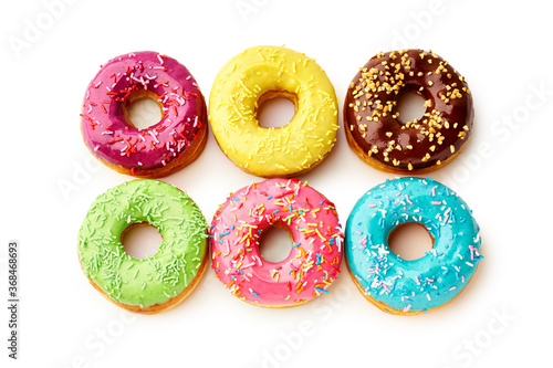 Sweet colorful glazed doughnuts from above on white background. Junk food top view, sugar treat