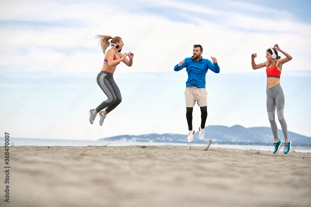 .Fitness people jumping and doing some fitness workout on the beach. .Fitness people jumping and doing some fitness workout on the beach.