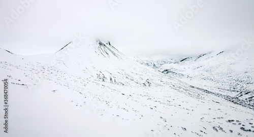 Photography White mountains of Kamchatka in fog and clouds after a snowfall.