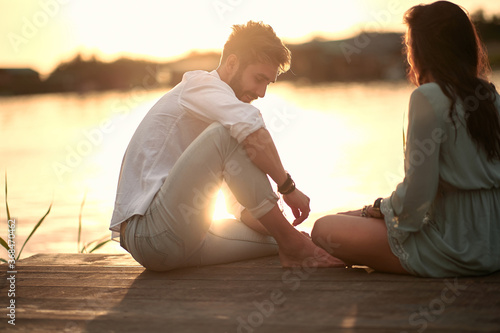 Couple in love having romantic tender moments on the river at sunset.