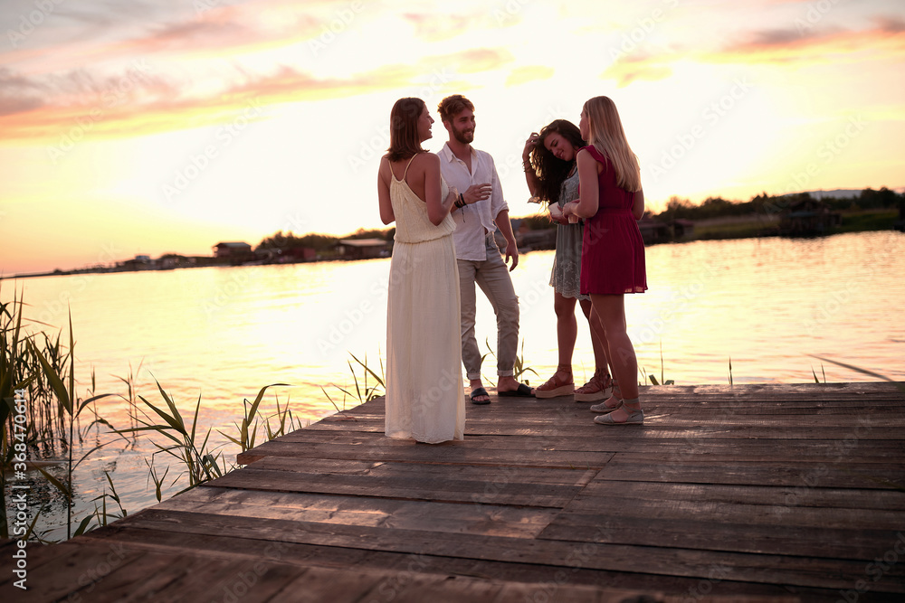 Beautiful time with friends at evening on river, talking and drinking. Beautiful time with friends at evening on river, talking and drinking.