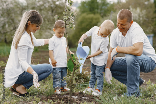 Family on a yard. Family with sons planting a tree. © prostooleh