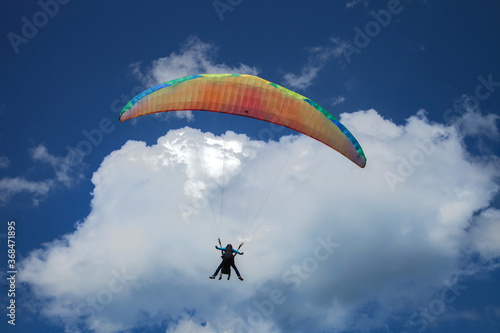 Parapentiste volant devant un cumulus