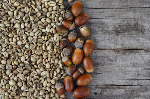  Flat lay of middle roasted coffee beans and acorn on wooden as background