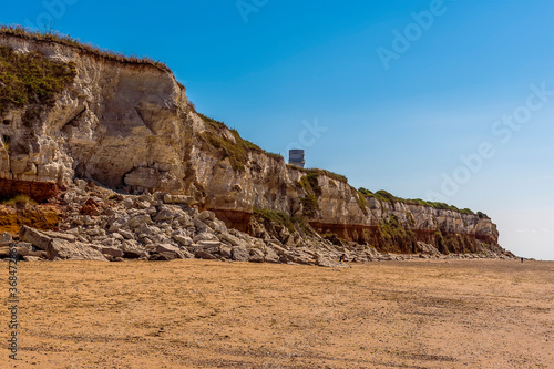 A view along the white, red and orange stratified chalk cliffs of Old Hunstanton, Norfolk, UK