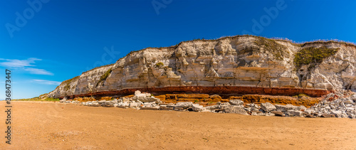 Foto A panorama view eastward along the white, red and orange stratified chalk cliffs