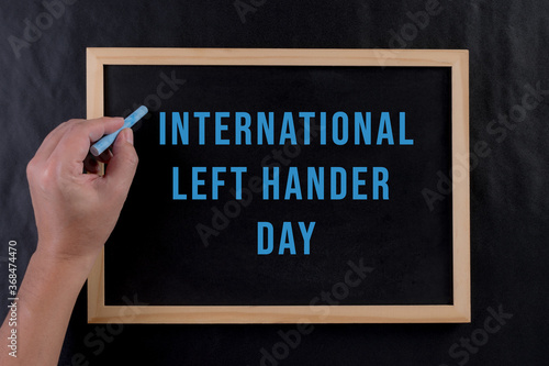 Man writing by left hand. Left hander day concept. International Lefthanders Day.