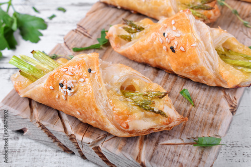 Green asparagus and cheese puff pastry folded as envelope and topped with sesame seeds
