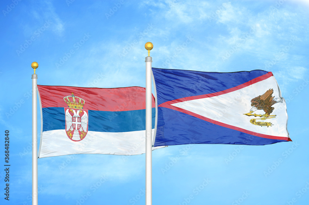 Serbia and American Samoa two flags on flagpoles and blue sky