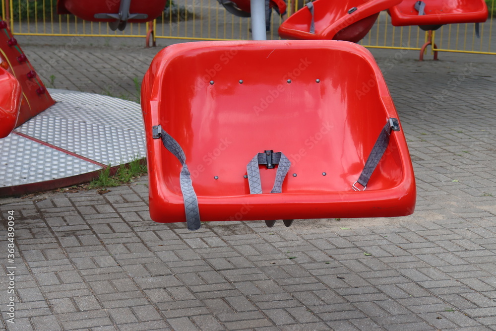 red plastic seat of speedy carousel