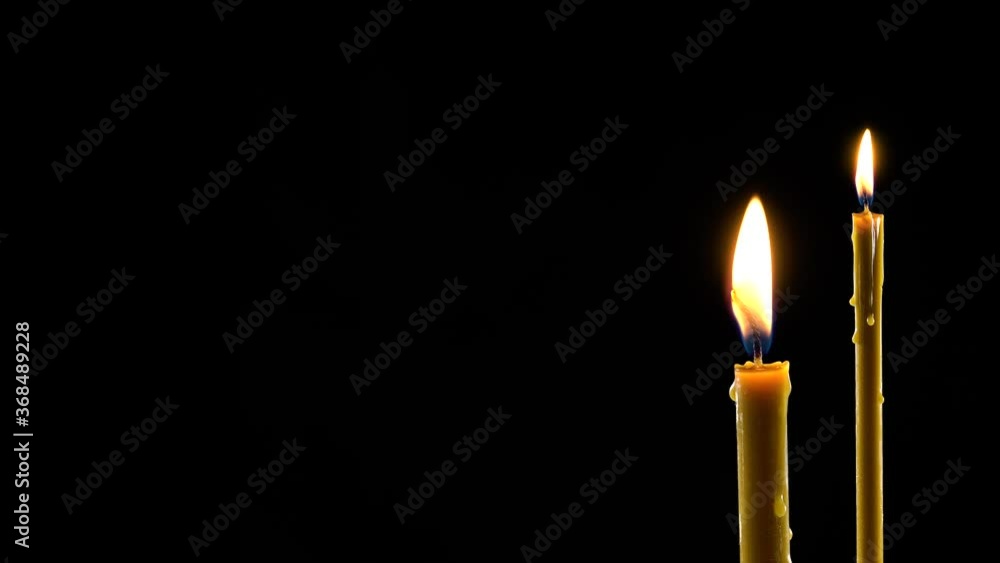 Two burning candles as a mocap or template with place for text. Black dramatic background. Two burning candles as a mocap or template with place for text. Black dramatic background.
