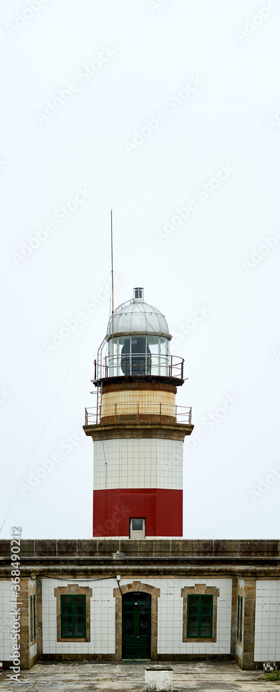 red and white lighthouse with cloudy sky