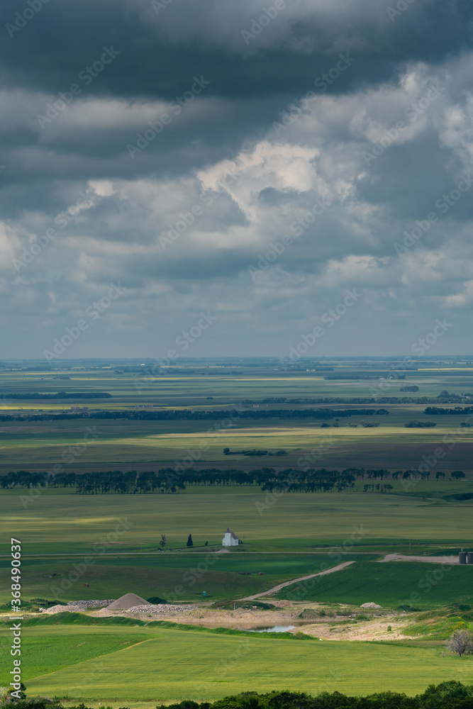 Aerial views Prairie landscapes of yellow and green fields under bold cloudy skies bright lighted areas