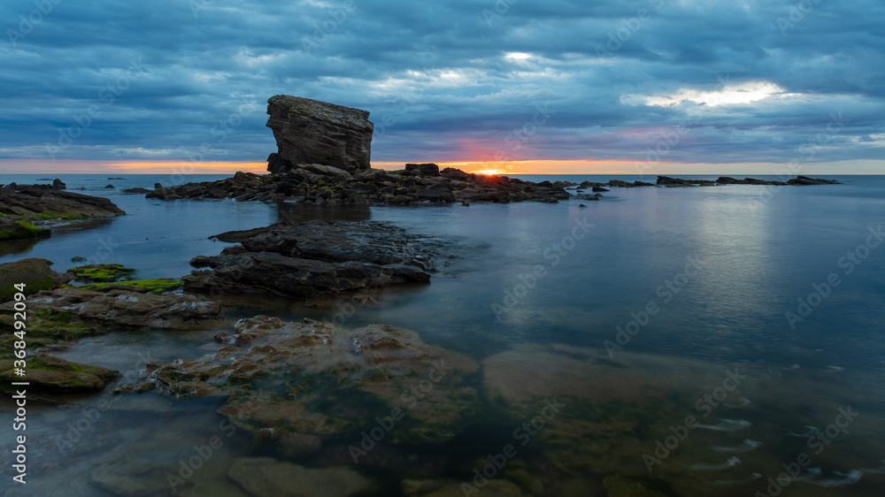 Sunrise at Charlies Garden, rock stack at Seaton Sluice, Northumberland, England, UK. On and overcast, cloudy morning. Sunrise at Charlies Garden, rock stack at Seaton Sluice, Northumberland, England, UK. On and overcast, cloudy morning.