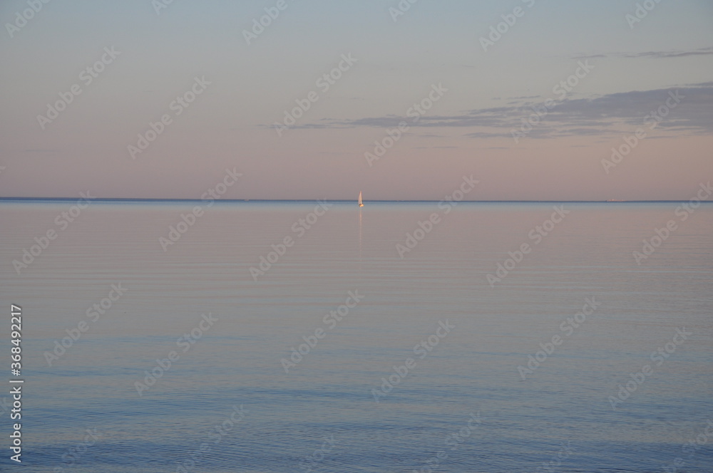 sailboat on the horizon of the Baltic sea at sunset