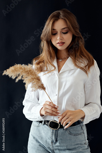 Girl in a white shirt with a spike of wheat in her hands