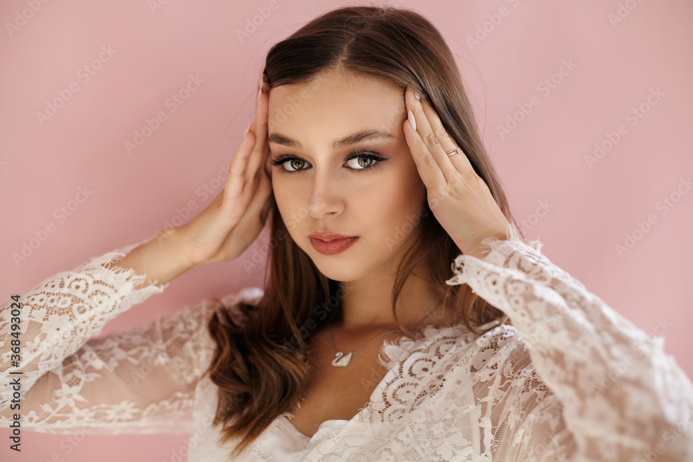Beautiful portrait of a girl in white clothes on a pink background Beautiful portrait of a girl in white clothes on a pink background