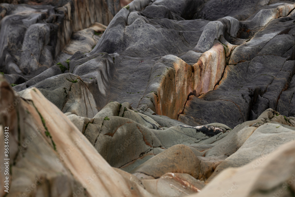 Φωτογραφία An abstract background of sea stones in the coastline, erosion lines of an ancient rock formation