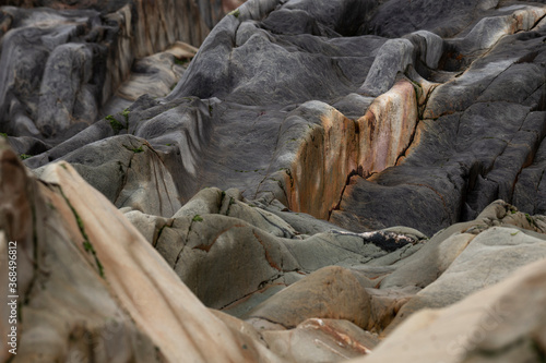 An abstract background of sea stones in the coastline, erosion lines of an ancient rock formation. 